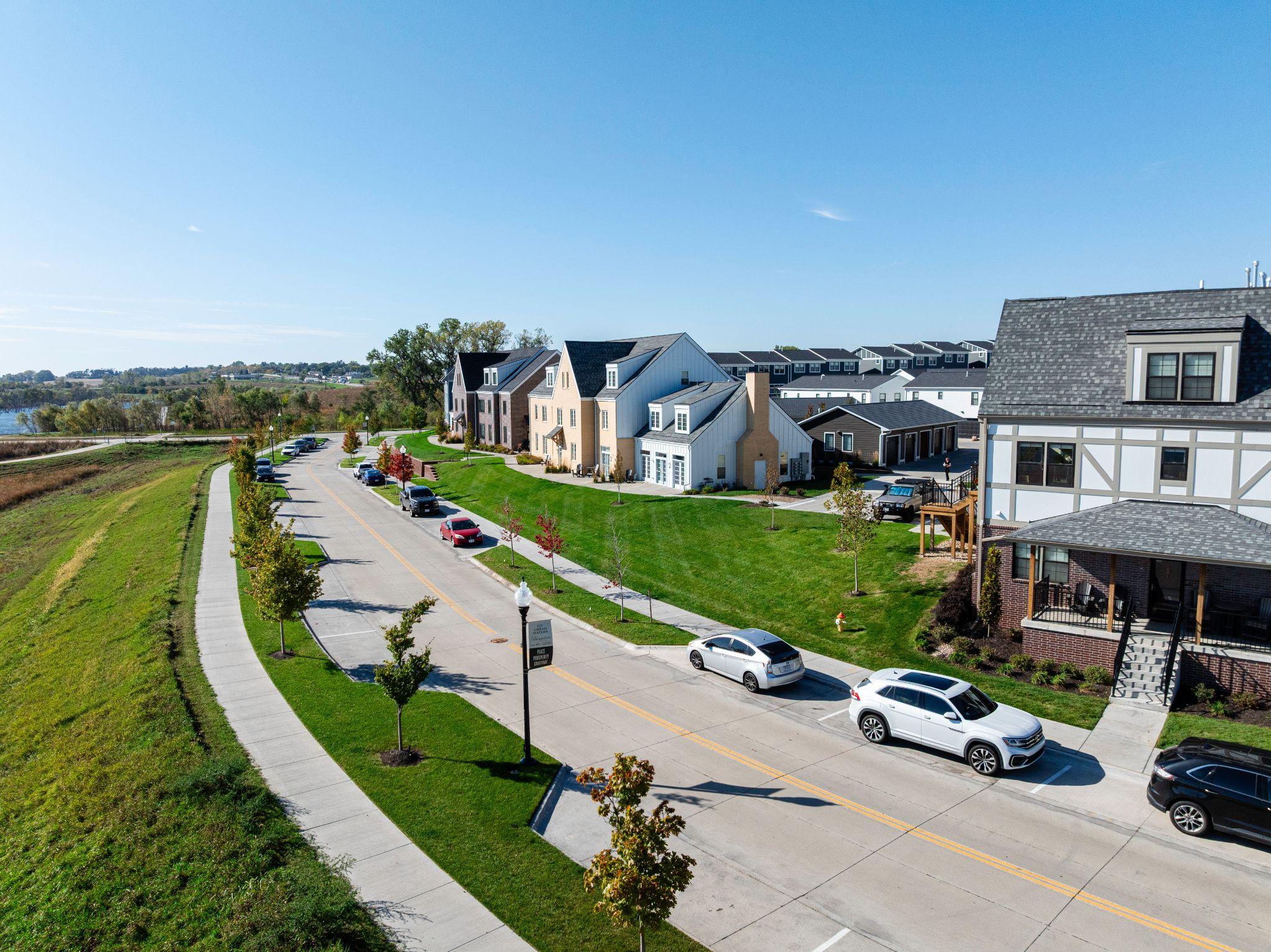 Aerial view of residential neighbourhood with green lawns and street trees.