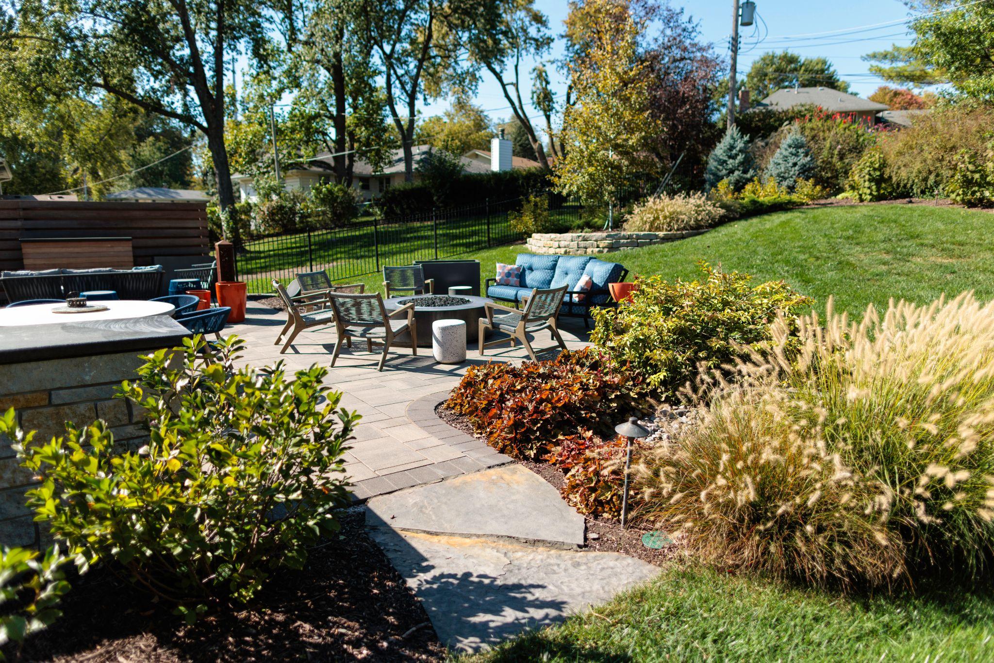 Backyard patio with outdoor furniture and surrounding landscaping.