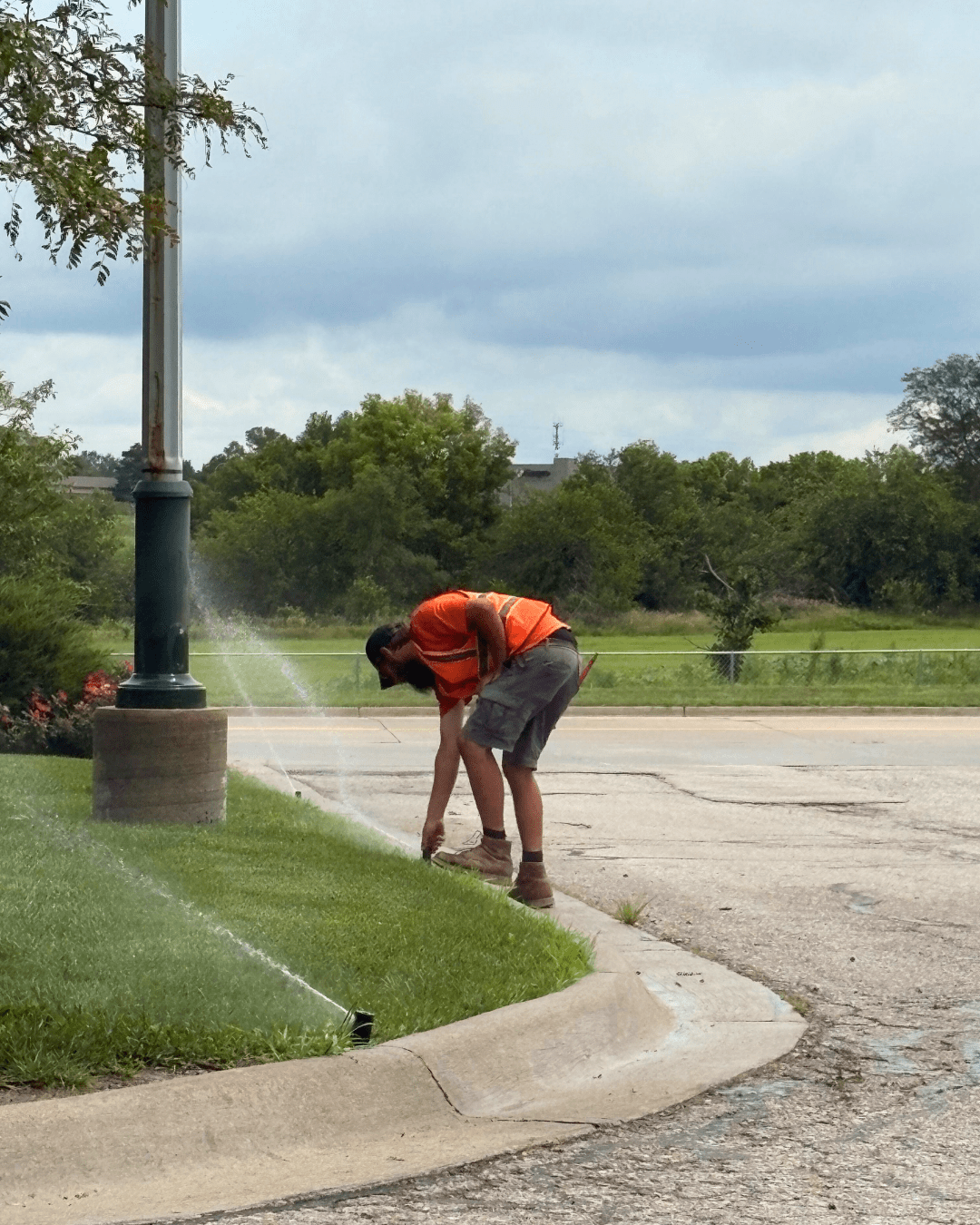 Technician adjusting a sprinkler head